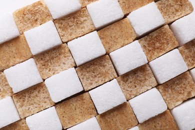 White and brown sugar cubes as background, top view