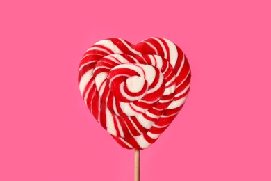 Photo of Sweet heart shaped lollipop on pink background, closeup. Valentine's day celebration