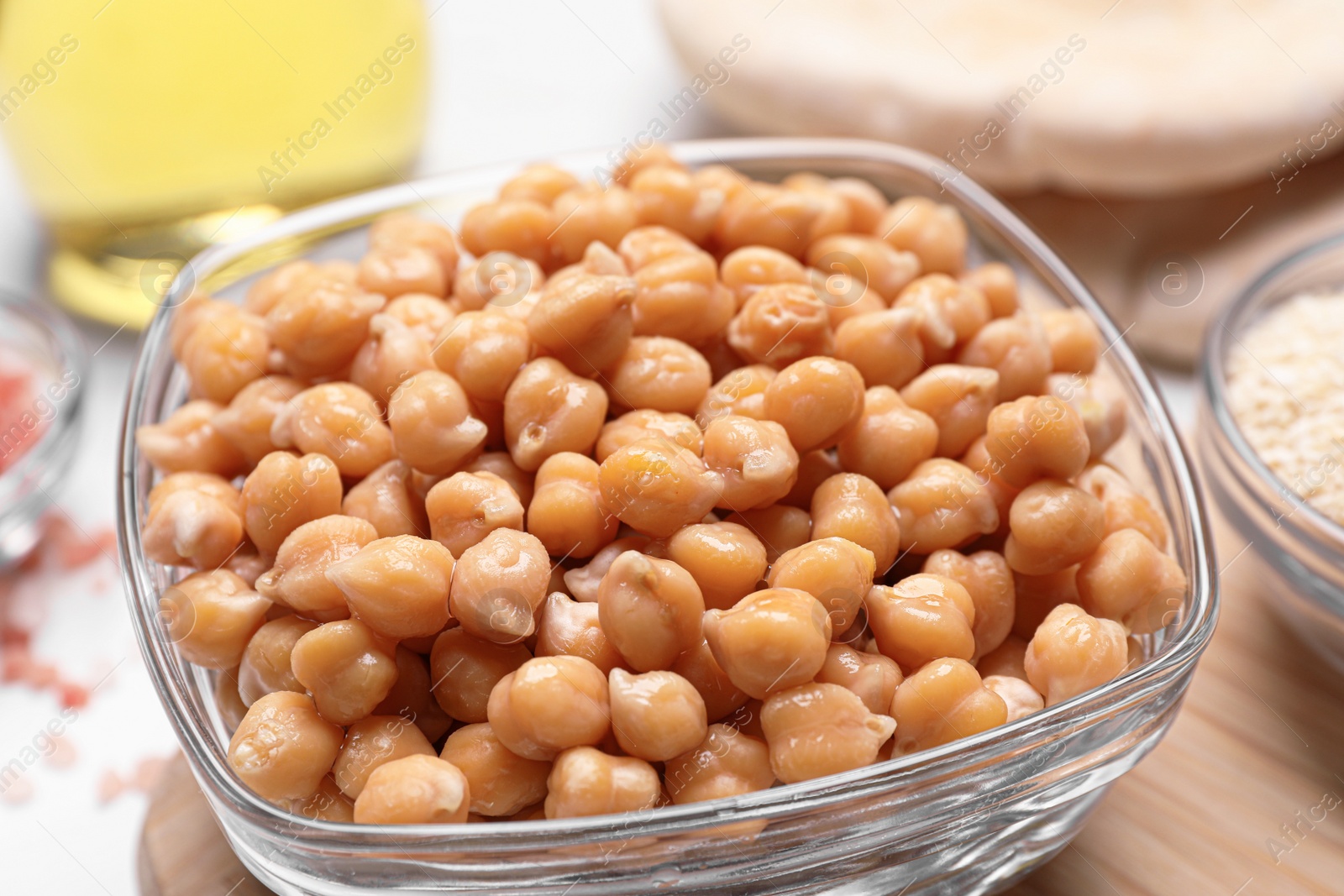 Photo of Delicious chickpeas on white table, closeup. Hummus ingredients