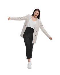 Photo of Beautiful businesswoman in suit walking on white background
