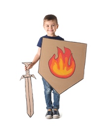 Photo of Cute little boy playing with cardboard sword and shield on white background