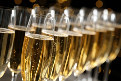 Many glasses of champagne on blurred background, closeup