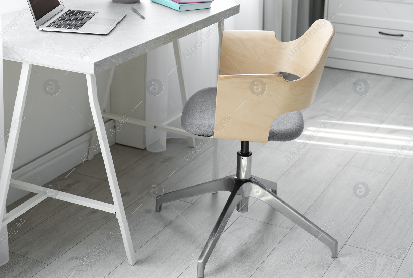 Photo of Comfortable workplace with office chair and modern table
