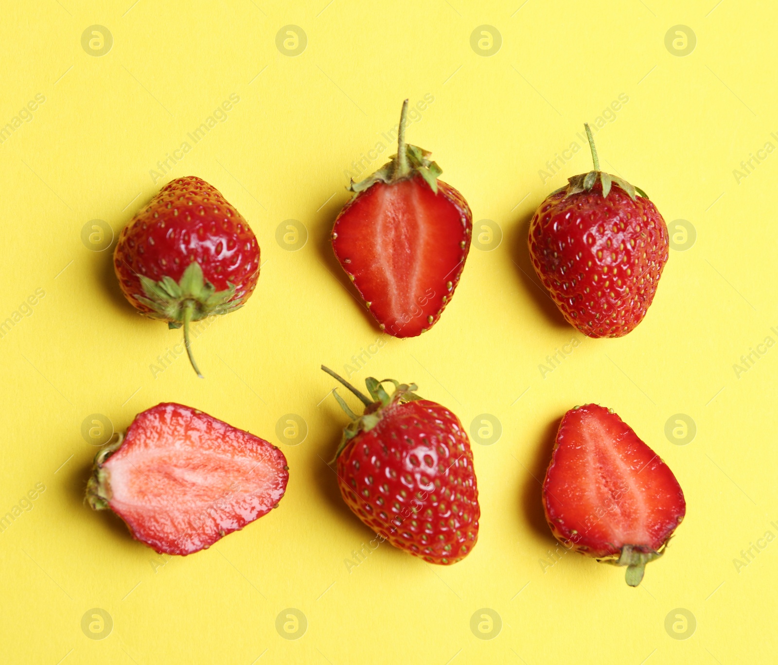 Photo of Tasty ripe strawberries on yellow background, flat lay