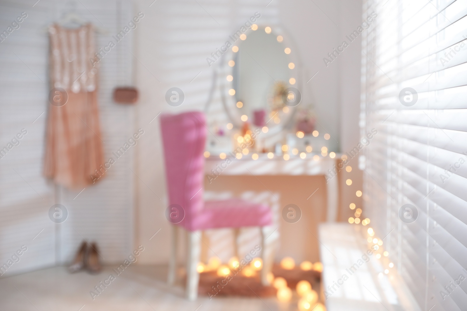 Photo of Blurred view of stylish room with dressing table and pink chair