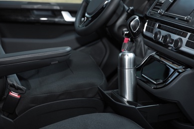 Photo of Silver thermos in holder inside of car