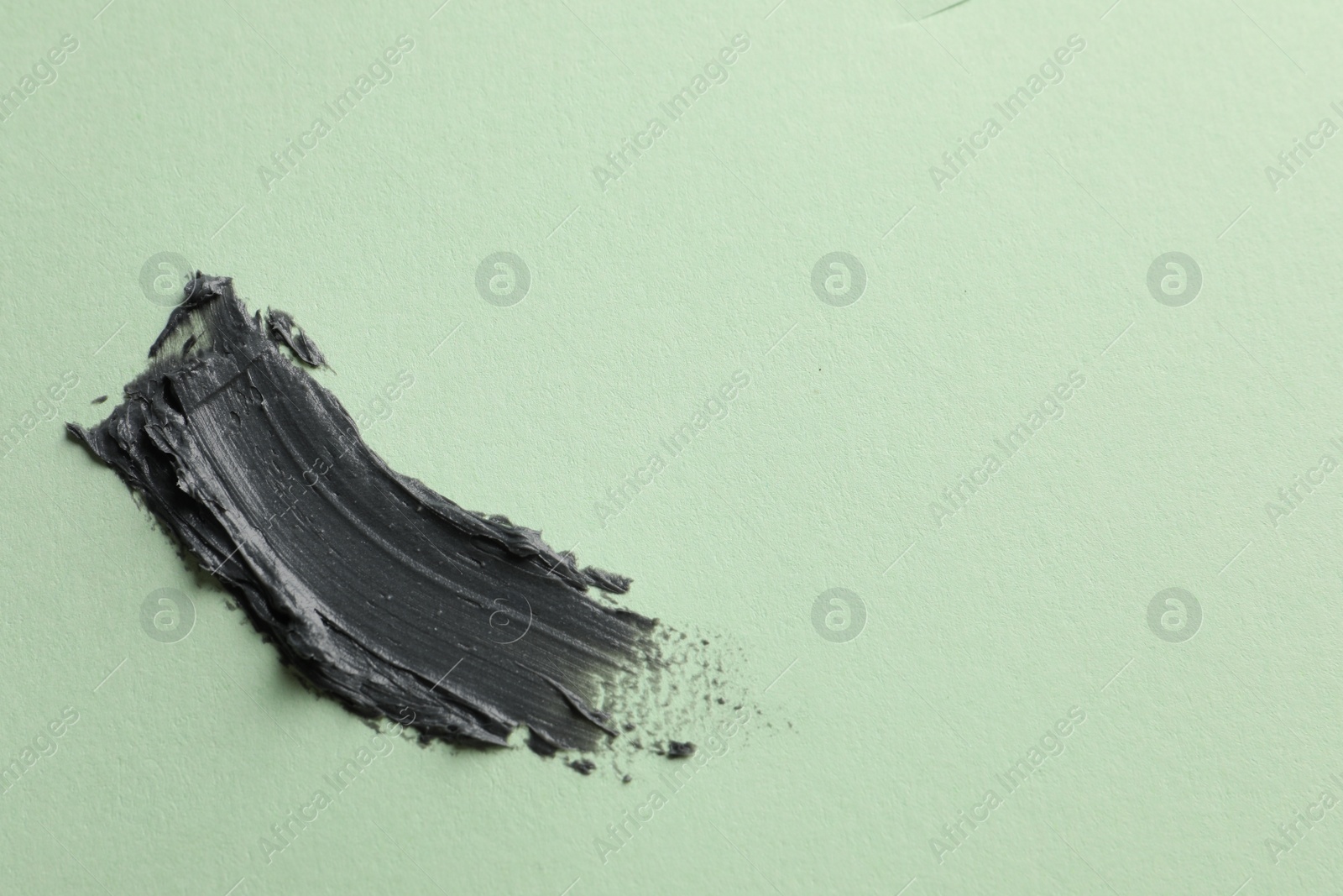 Photo of Sample of face mask on light green background, top view. Space for text