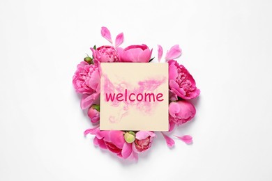 Image of Fresh peonies and card with word WELCOME on white background, top view