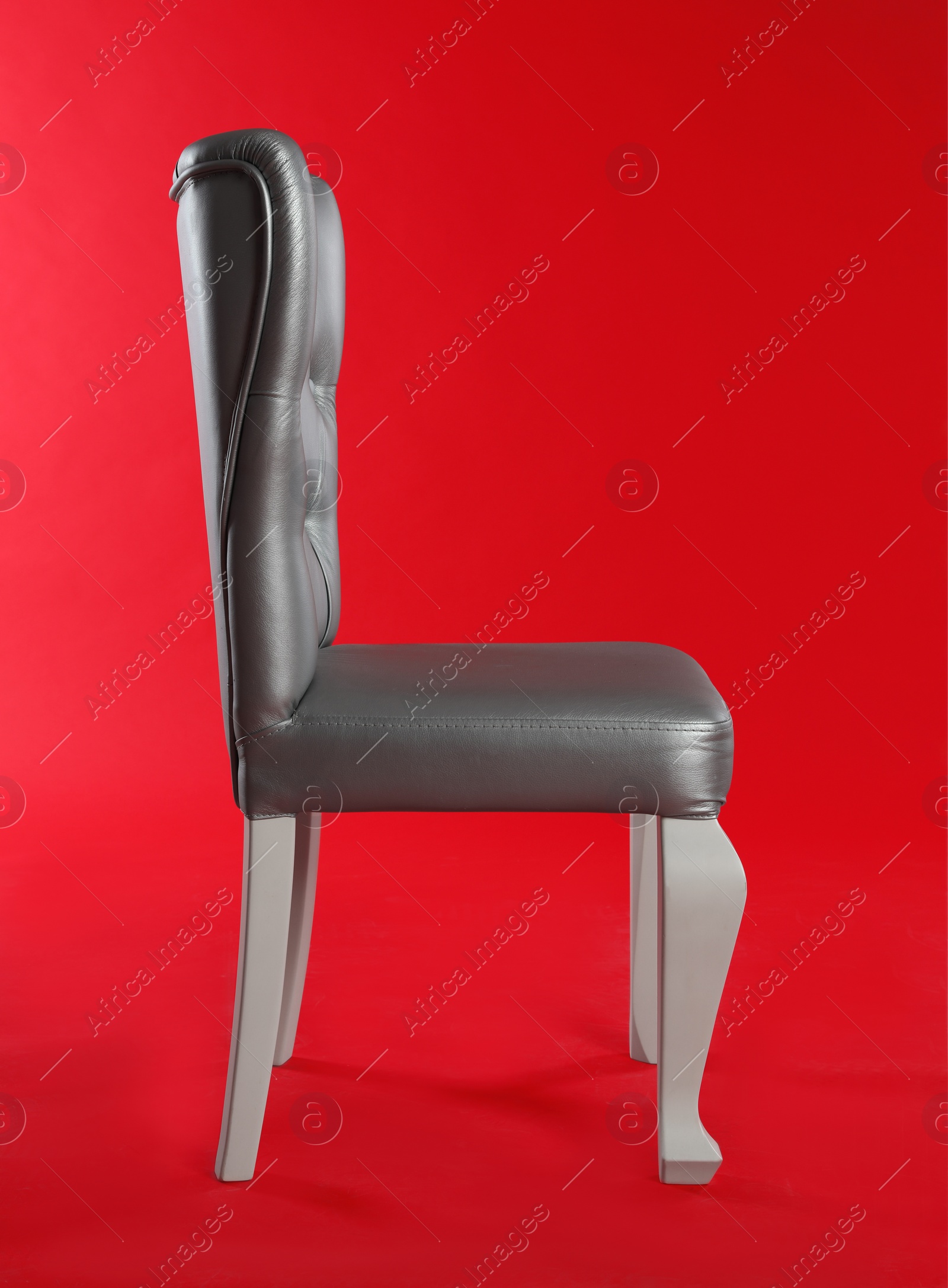 Photo of Stylish silver chair on red background. Element of interior design