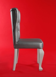 Stylish silver chair on red background. Element of interior design