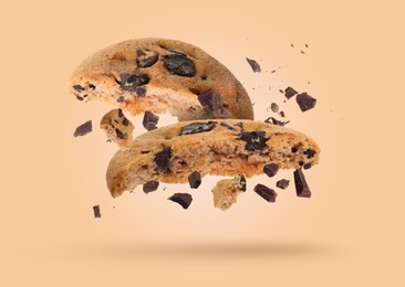 Image of Tasty chocolate chip cookies falling on pale light brown background