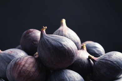 Photo of Fresh ripe figs against black background, closeup