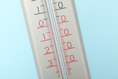Weather thermometer on light blue background, closeup