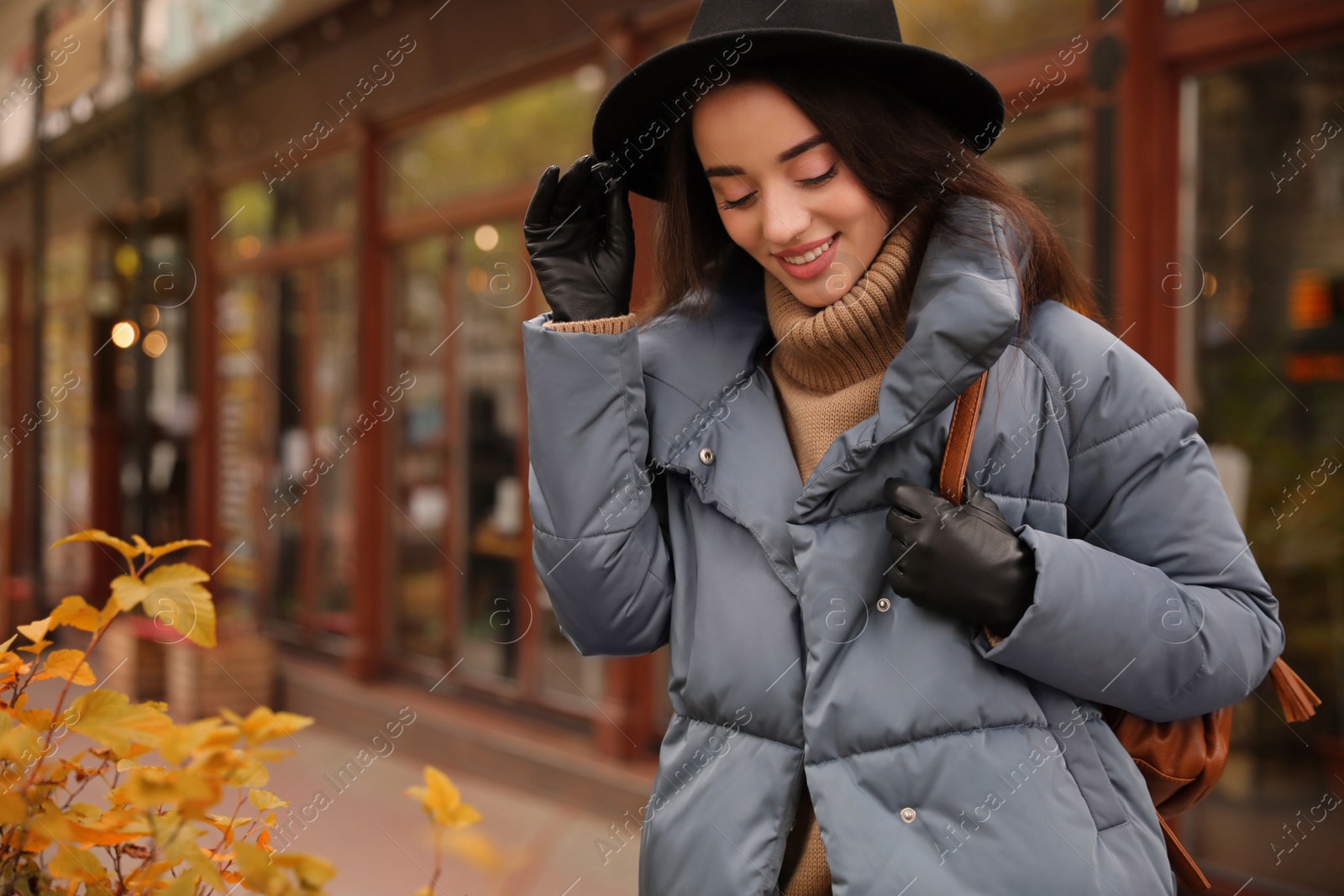 Photo of Young woman wearing stylish clothes on city street, space for text. Autumn look