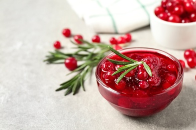 Cranberry sauce, rosemary and fresh berries on light table, space for text