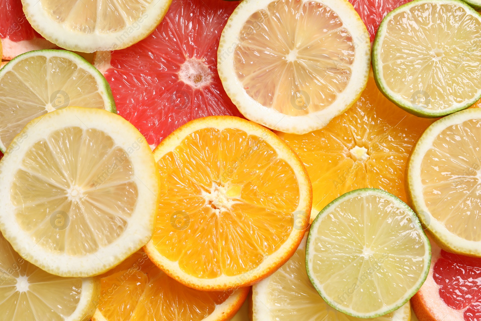 Photo of Different sliced citrus fruits as background, top view