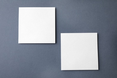 Photo of Blank note papers on dark grey background, flat lay. Mock up for design