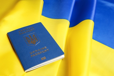 Photo of Ukrainian travel passport on national flag, space for text. International relationships
