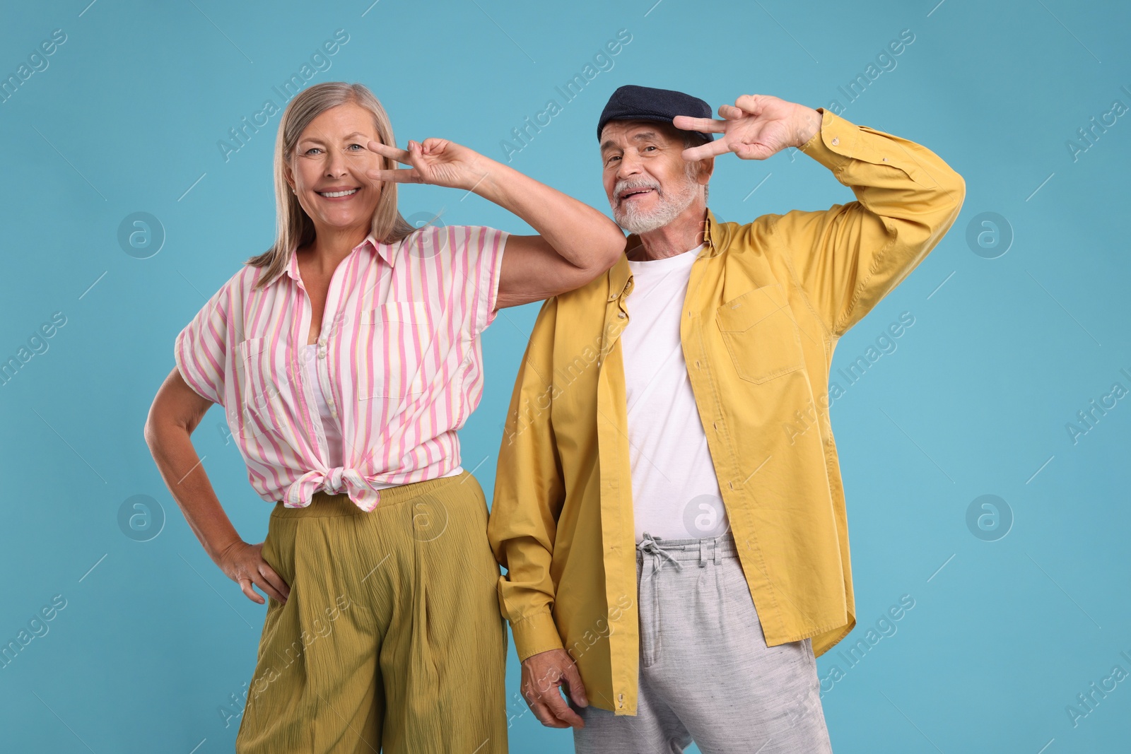 Photo of Senior couple dancing together on light blue background