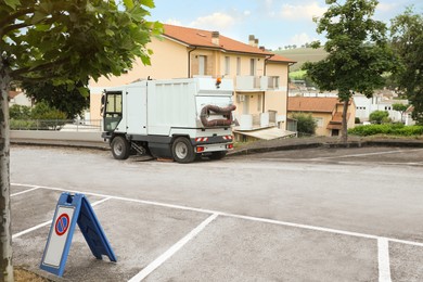 Modern sweeping car on road in city