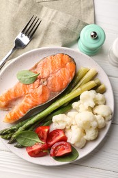 Photo of Healthy meal. Grilled salmon steak and vegetables served on white wooden table, flat lay