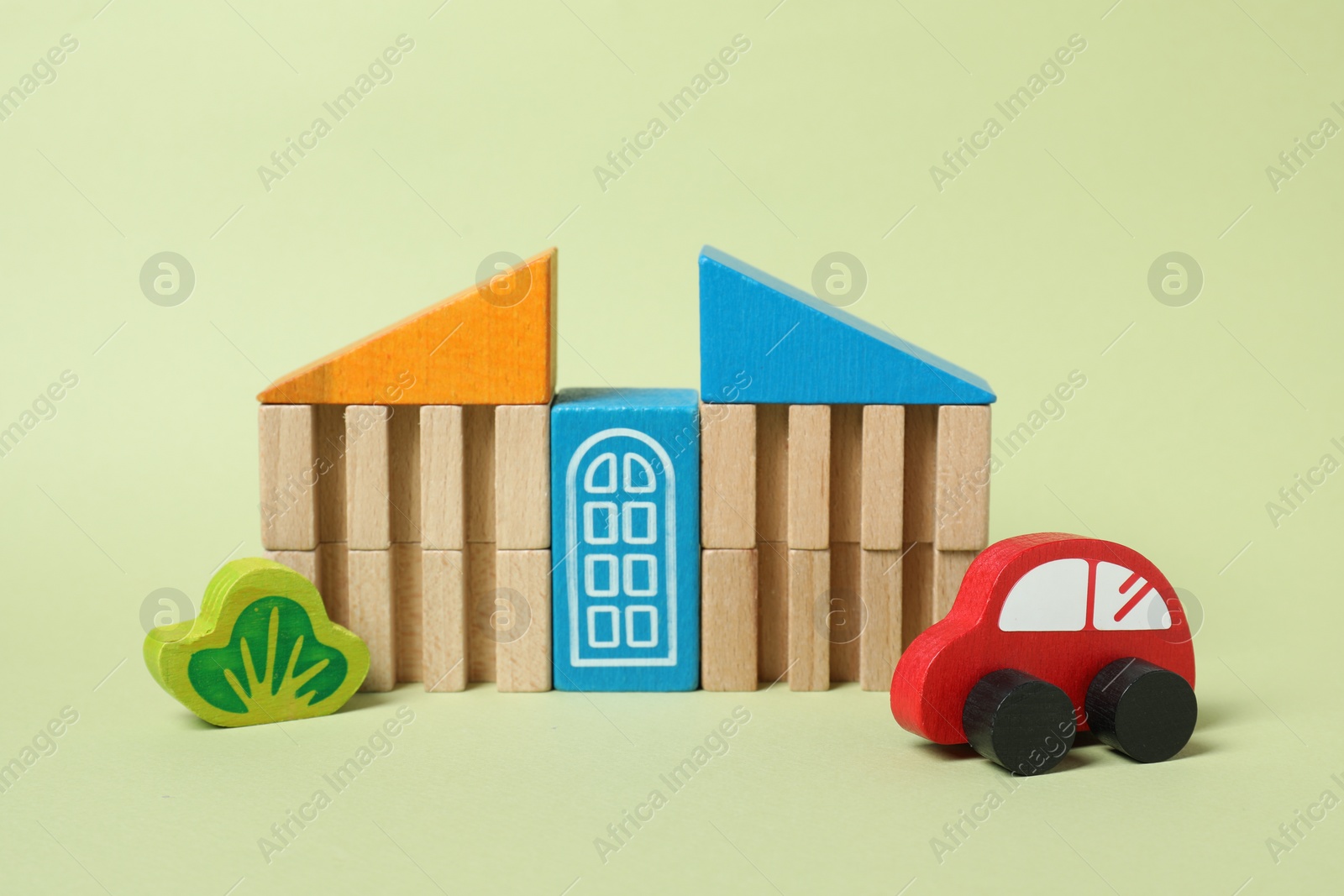 Photo of Set of wooden toys on pale light green background. Children's development