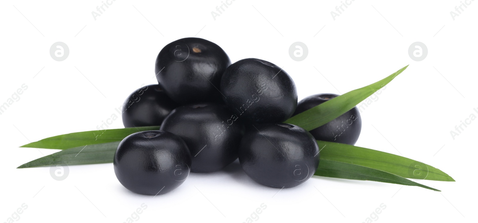 Photo of Pile of fresh ripe acai berries and green leaves on white background