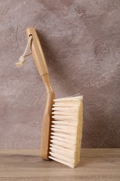 Photo of One cleaning brush with wooden handle on table