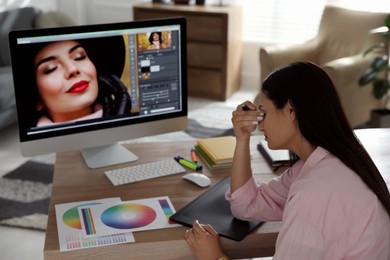 Tired retoucher at workplace with computer in office