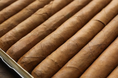 Photo of Many expensive cigars in box on table, closeup