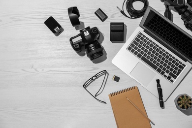 Flat lay composition with equipment for professional photographer on wooden background. Space for text