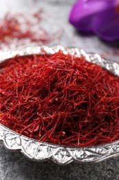 Dried saffron and crocus flower on grey table, closeup