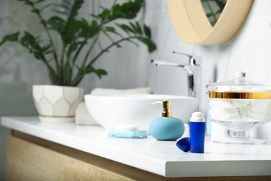 Photo of Stick deodorant and different toiletry on countertop in bathroom, space for text