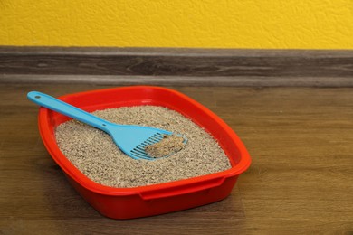 Photo of Cat tray with clumping litter and scoop on floor indoors