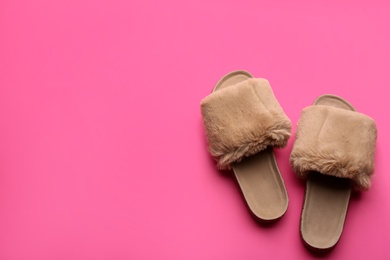 Pair of soft slippers on pink background, flat lay. Space for text