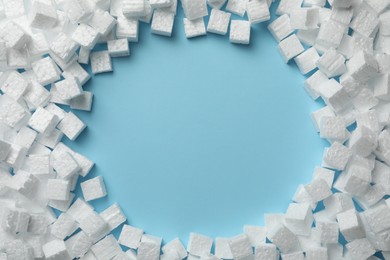 Photo of Frame made of styrofoam cubes on light blue background, flat lay. Space for text