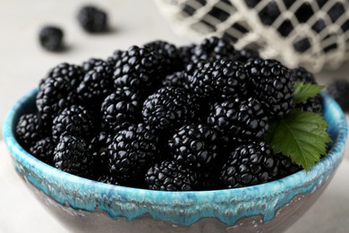 Photo of Tasty ripe blackberries in bowl on table, closeup