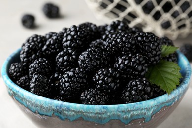 Tasty ripe blackberries in bowl on table, closeup