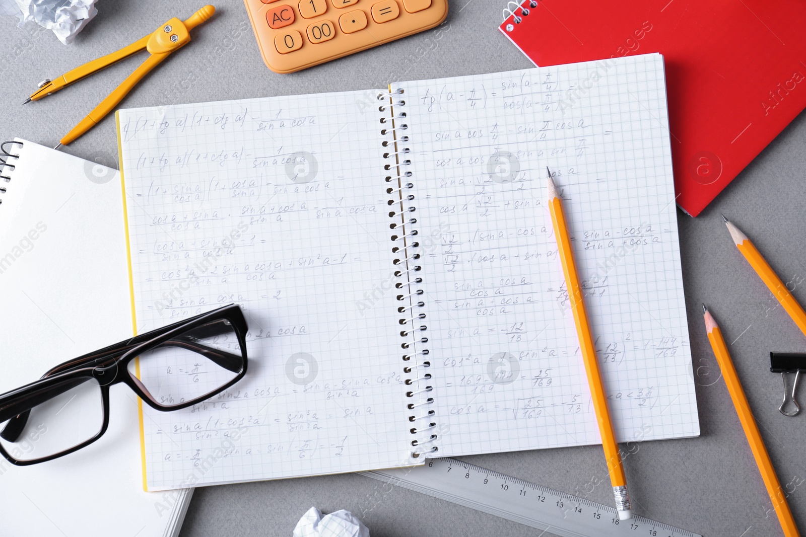 Photo of Flat lay composition with open notebook on light grey table. Doing homework