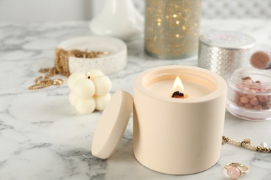 Photo of Composition with burning soy candles on white marble table, space for text