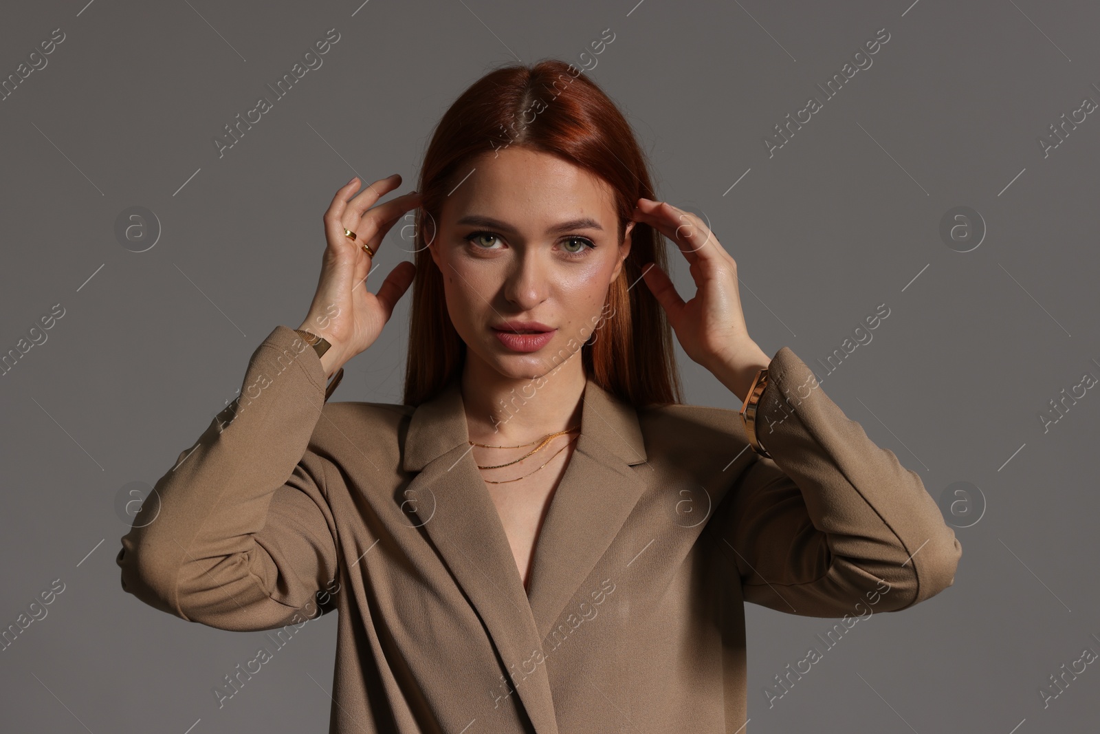 Photo of Beautiful young woman with elegant jewelry on gray background