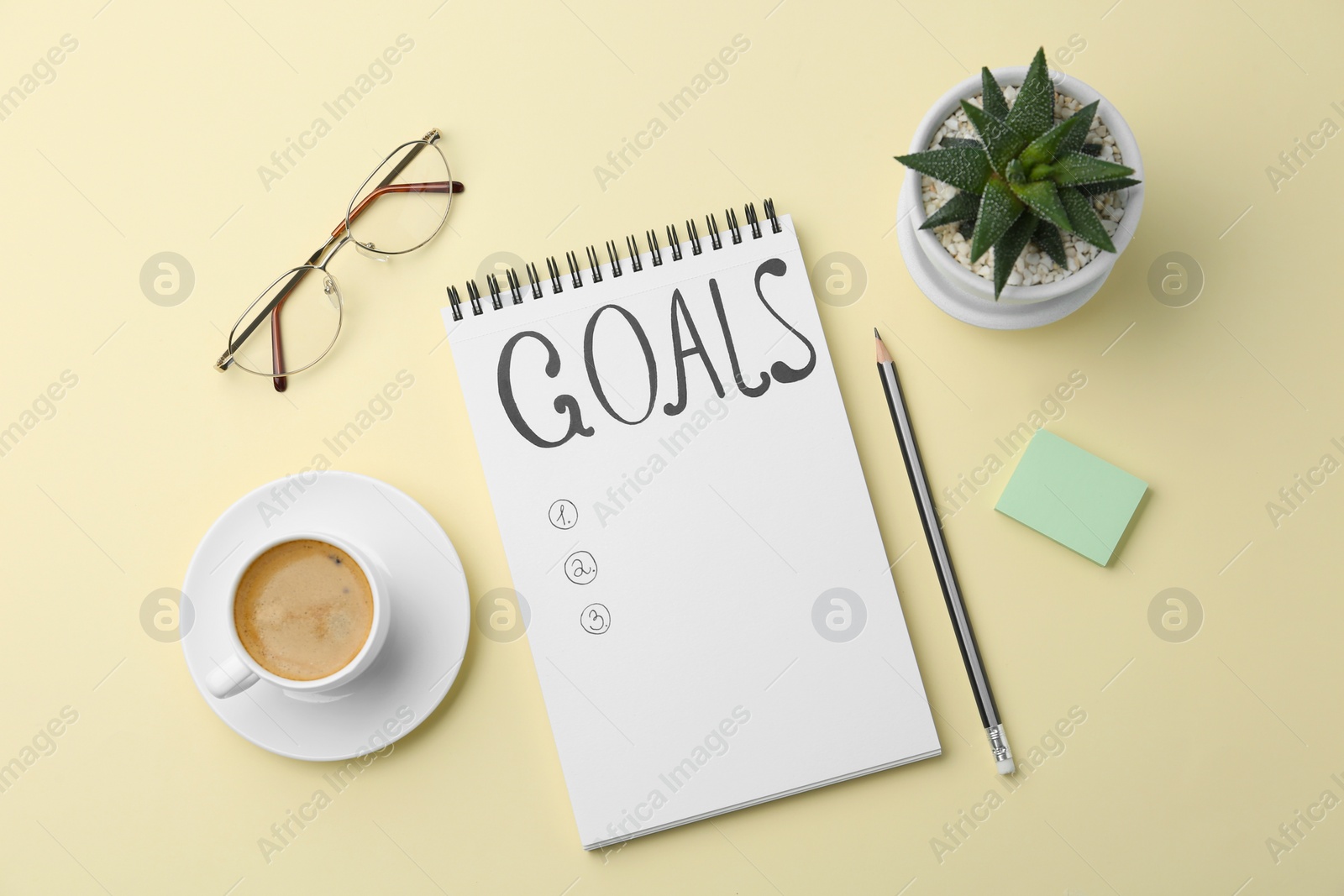 Photo of Planning concept. Empty list of goals in notebook and coffee on beige background, flat lay