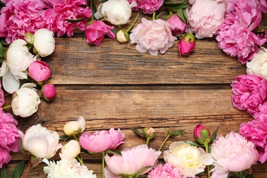 Photo of Frame made of beautiful peonies on wooden background, flat lay. Space for text