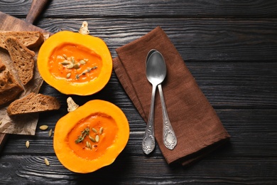 Photo of Flat lay composition with cream soup served in pumpkin on table