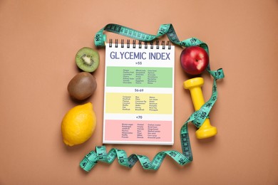 Glycemic index. Information about grouping of products under their GI in notebook, measuring tape, dumbbell and fruits on light brown background, flat lay