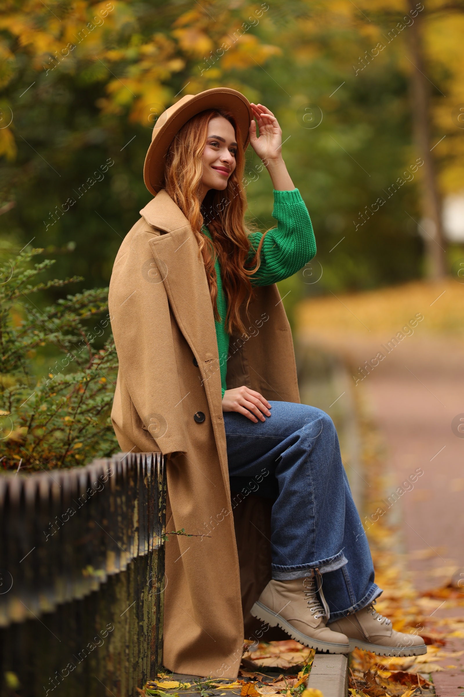 Photo of Portrait of beautiful woman sitting in autumn park