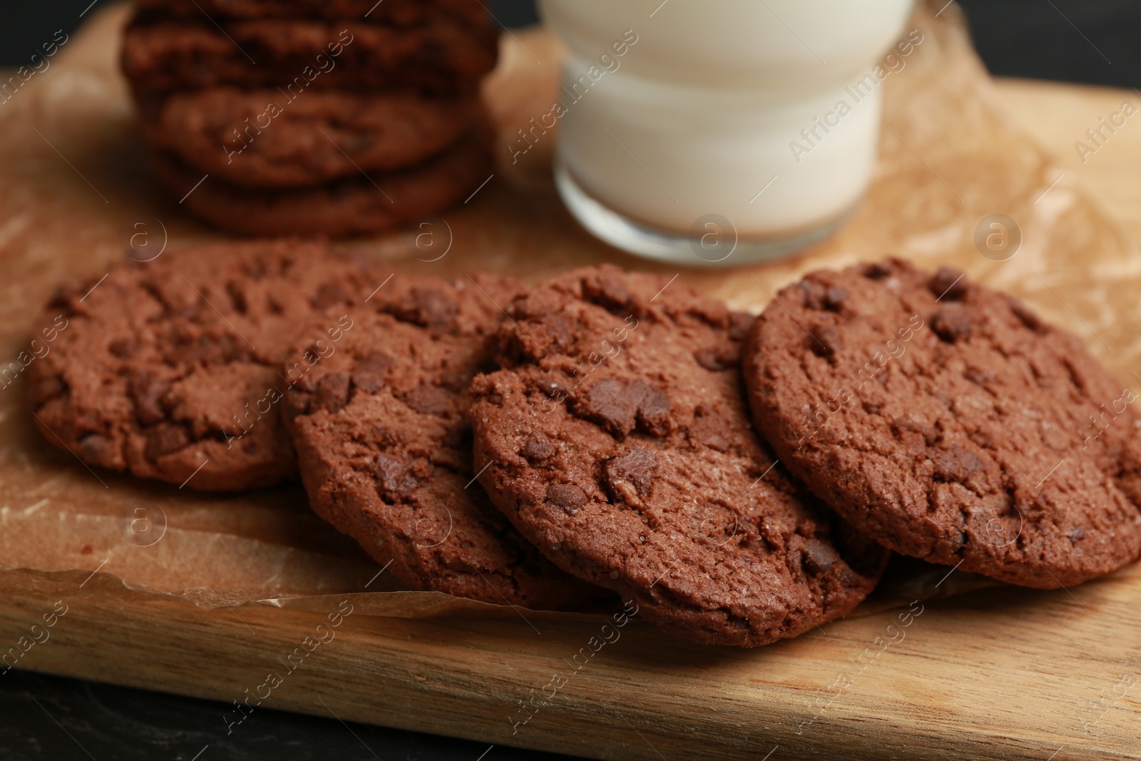 Photo of Tasty chocolate cookies on wooden board, closeup