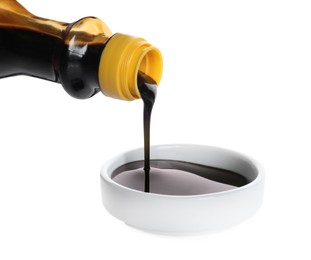 Photo of Pouring soy sauce into bowl against white background