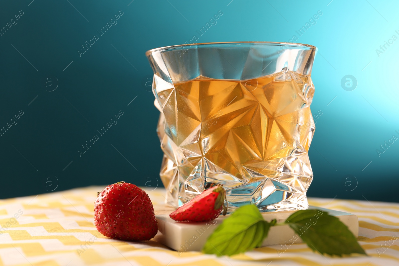 Photo of Glass of alcohol drink, strawberries and mint on table