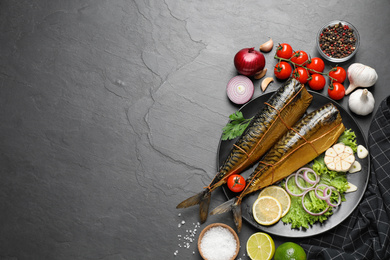 Photo of Flat lay composition with tasty smoked fish on dark table, space for text